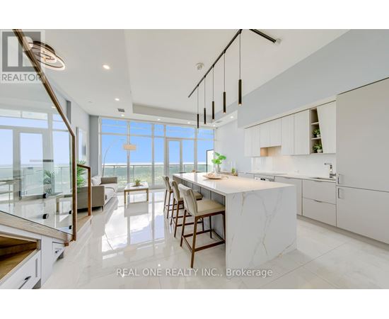 A modern kitchen with white cabinets and a marble island.