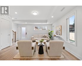 A well-lit living room with a beige sofa and matching armchairs.