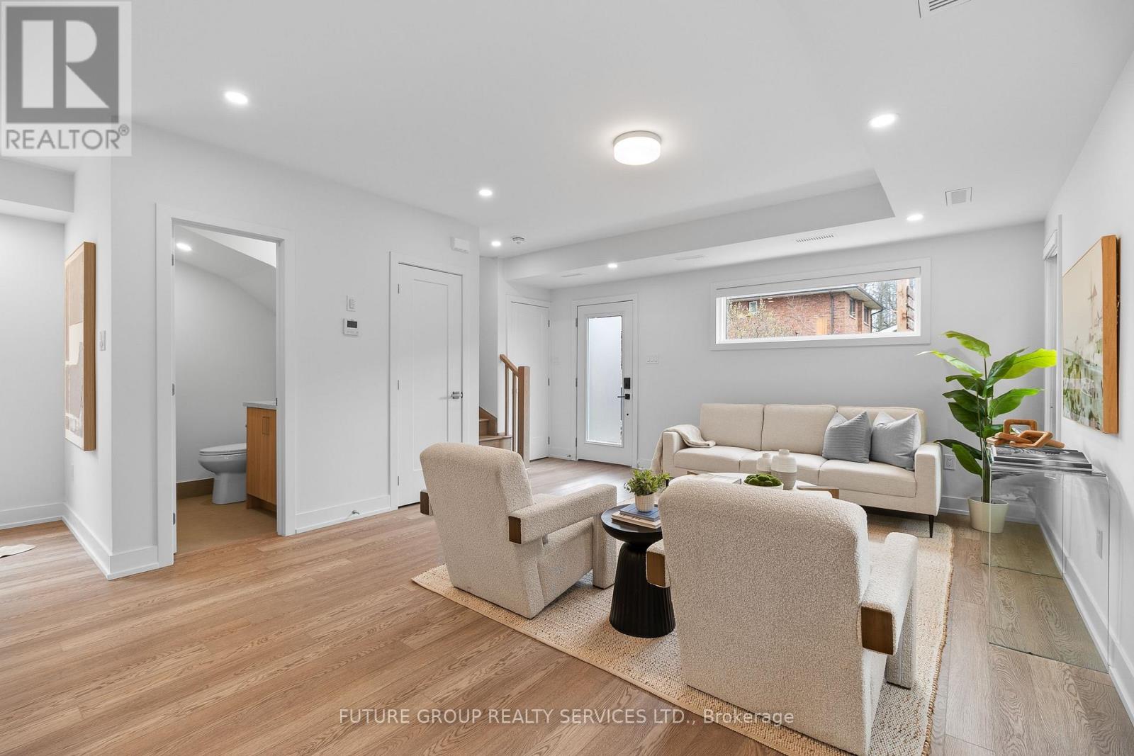 A well-lit living room with a couch, armchairs, and a coffee table.