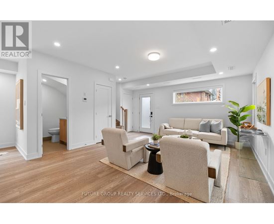 A well-lit living room with a couch, armchairs, and a coffee table.