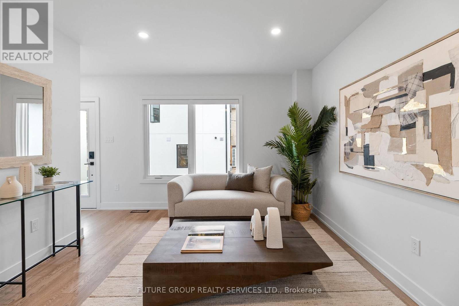 A modern living room with a glass coffee table and a large abstract painting on the wall.