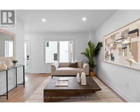 A modern living room with a glass coffee table and a large abstract painting on the wall.