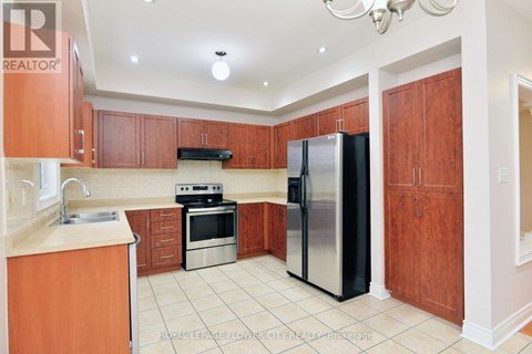 A kitchen with wooden cabinets and a black refrigerator.