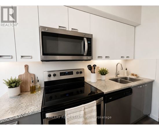 A modern kitchen with a black oven and white cabinets.