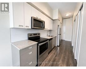 A kitchen with white cabinets and a microwave above the stove.