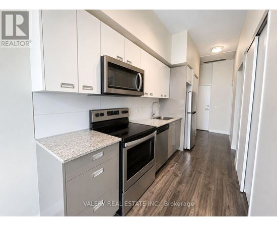 A kitchen with white cabinets and a microwave above the stove.