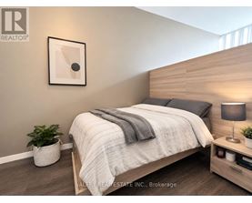 A bedroom with a bed, nightstand, and lamp.