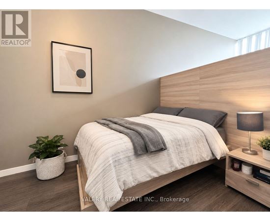 A bedroom with a bed, nightstand, and lamp.