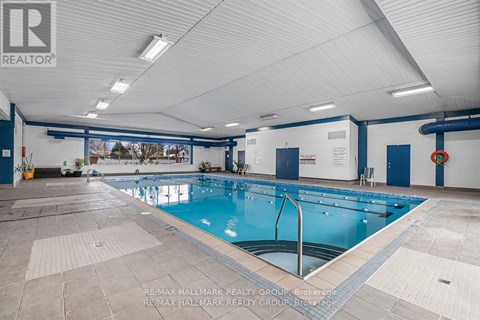 A large indoor swimming pool with a blue bottom and white walls.