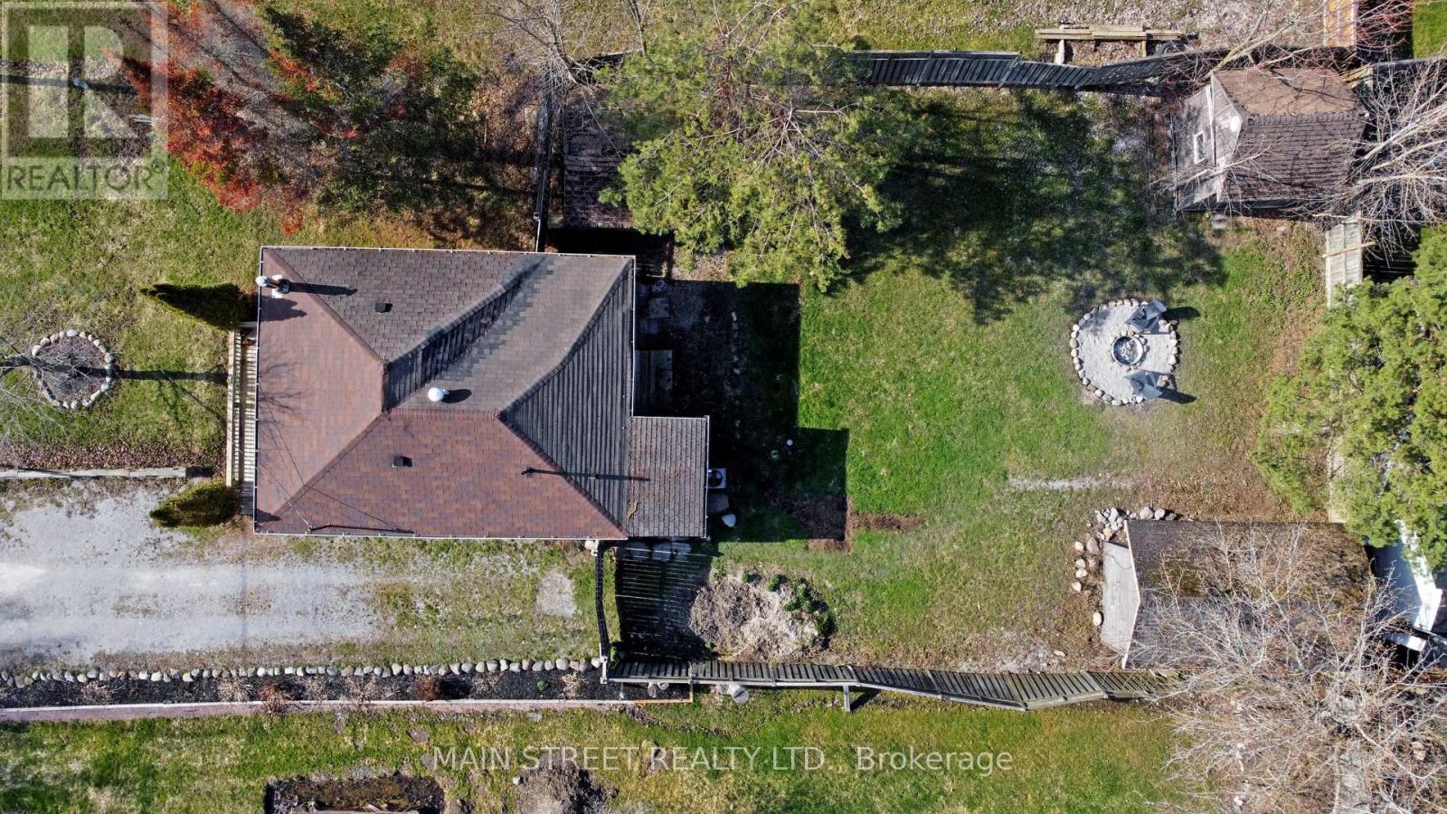 A house with a brown roof is surrounded by a grassy area.