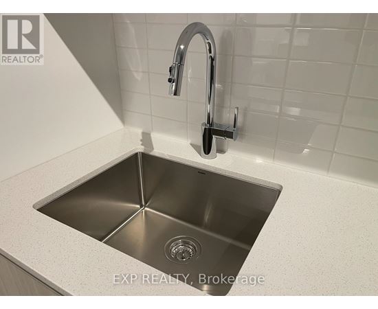 A modern kitchen sink with a chrome faucet.