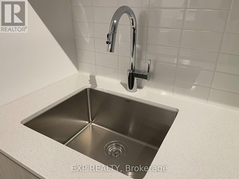 A modern kitchen sink with a chrome faucet.