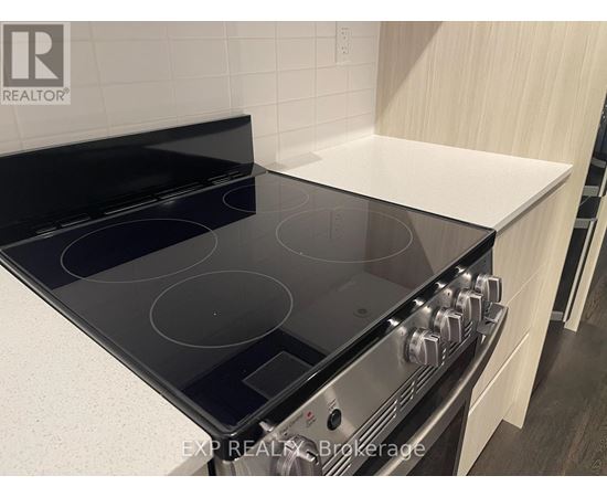 A modern kitchen with a black stove top oven.