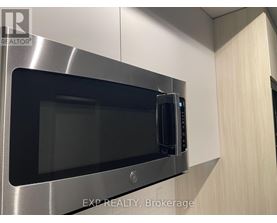 A microwave oven is built into a stainless steel kitchen cabinet.