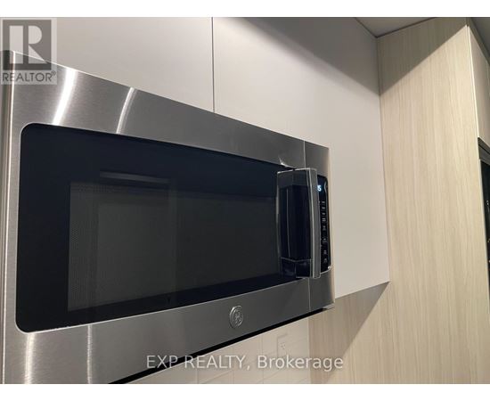 A microwave oven is built into a stainless steel kitchen cabinet.