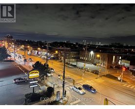 A city street at night with cars and buildings.