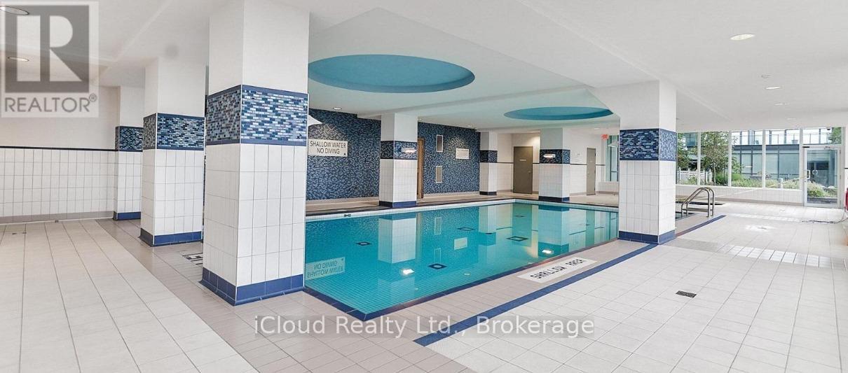 A large indoor swimming pool with a blue tiled wall.
