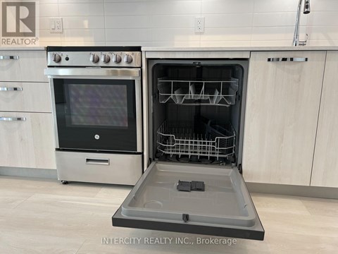 A modern kitchen with a stainless steel oven and a dishwasher.