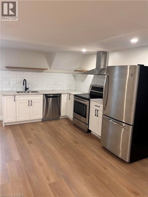 A kitchen with wooden floors and stainless steel appliances.