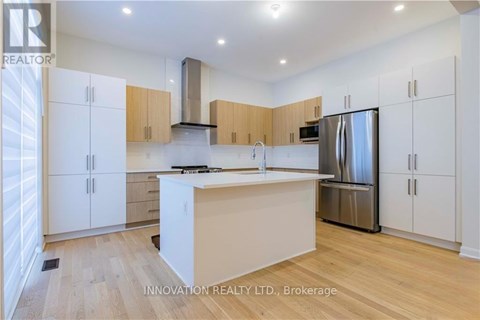 A modern kitchen with white cabinets and a wooden island.