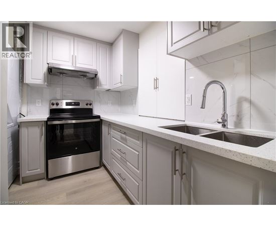 A modern kitchen with white cabinets and stainless steel appliances.