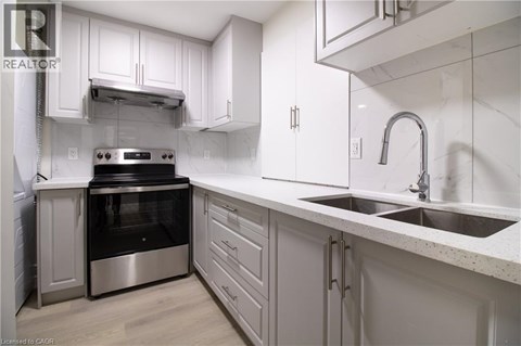 A modern kitchen with white cabinets and stainless steel appliances.