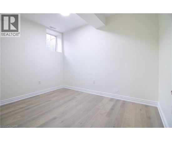A room with wooden flooring and white walls.