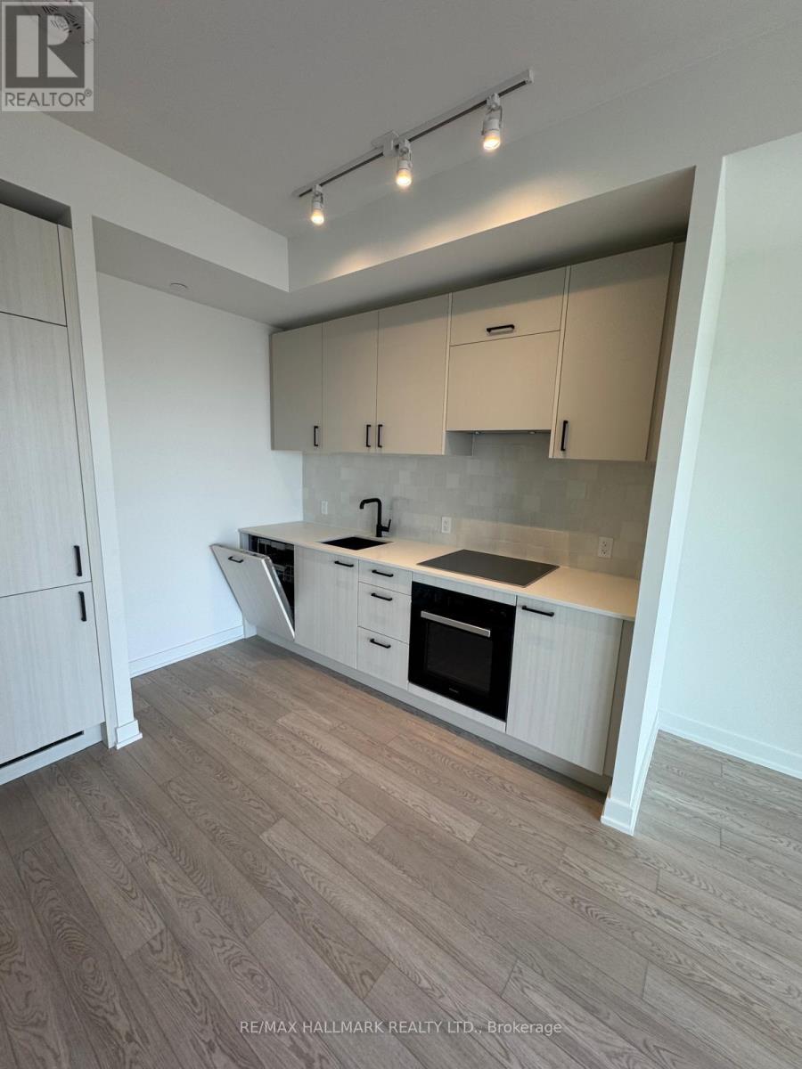 A kitchen with white cabinets and a wooden floor.