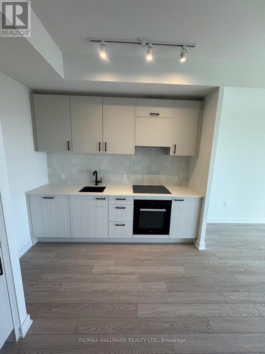 A kitchen with white cabinets and a black countertop.