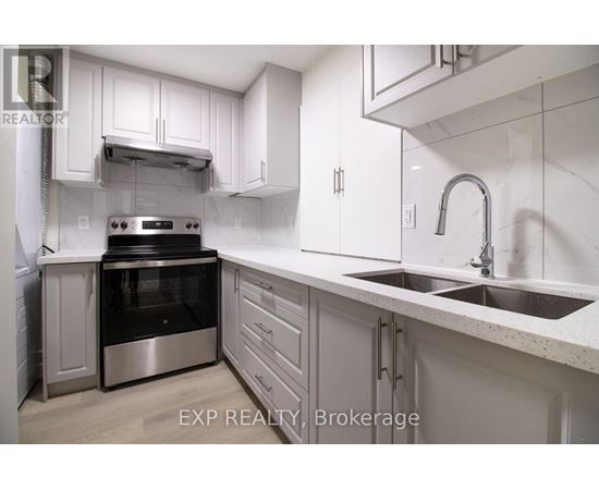 A modern kitchen with white cabinets and stainless steel appliances.