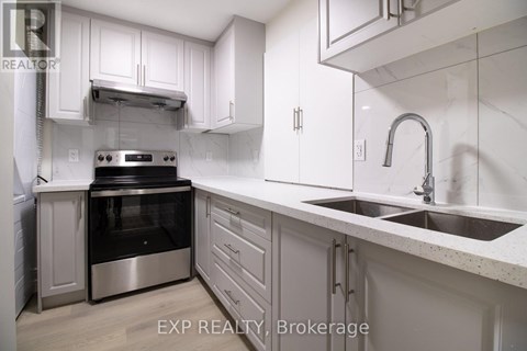A modern kitchen with white cabinets and stainless steel appliances.