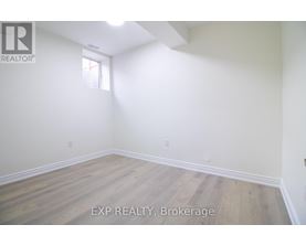 A room with wooden flooring and white walls.