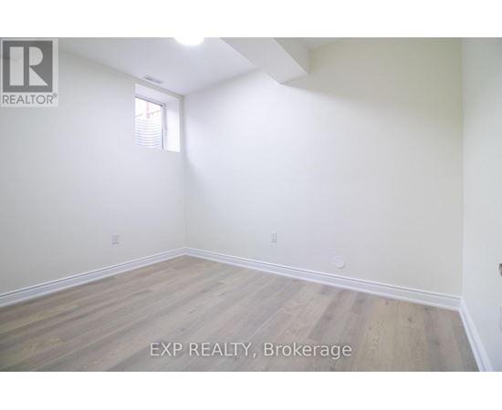 A room with wooden flooring and white walls.