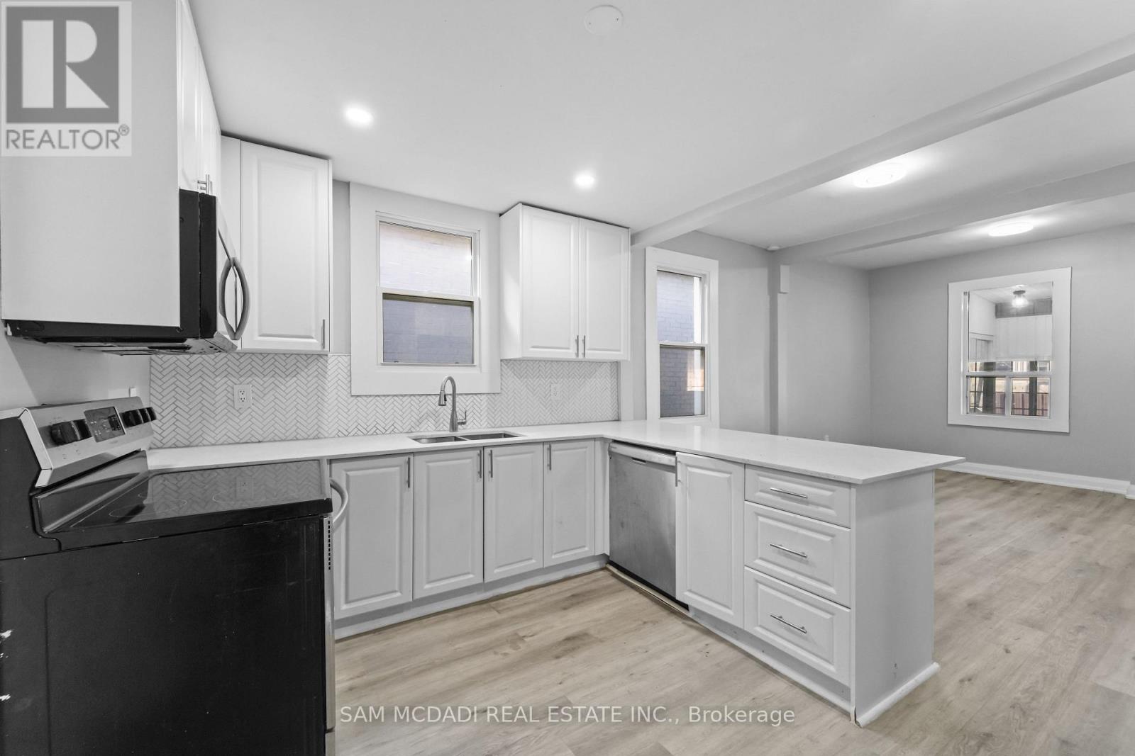 A kitchen with white cabinets and a black stove top oven.