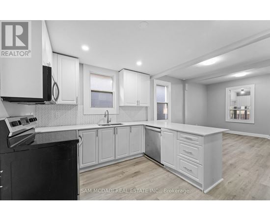 A kitchen with white cabinets and a black stove top oven.
