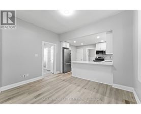 A spacious room with a kitchenette and a refrigerator.