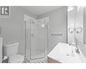 A white bathroom with a glass shower stall and a toilet.