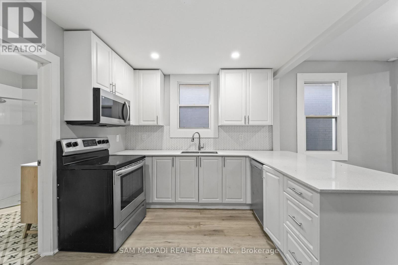 A kitchen with black appliances and white cabinets.