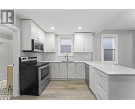 A kitchen with black appliances and white cabinets.