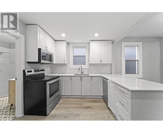 A kitchen with black appliances and white cabinets.