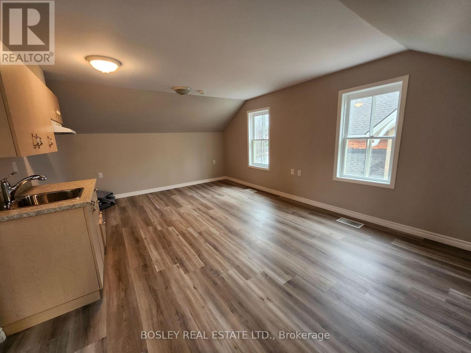A room with wooden flooring and a window.