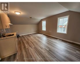 A room with wooden flooring and a window.