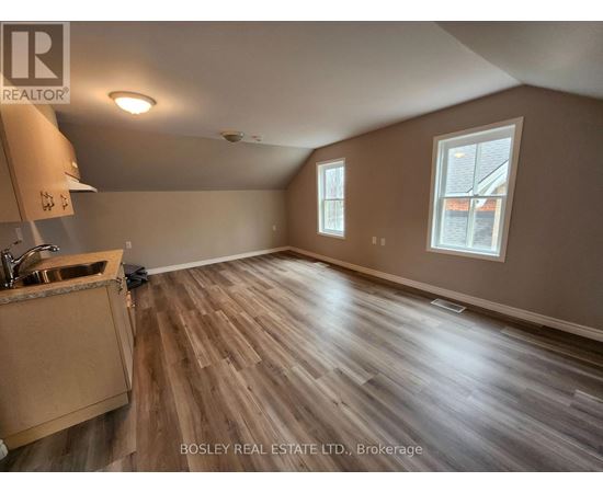 A room with wooden flooring and a window.