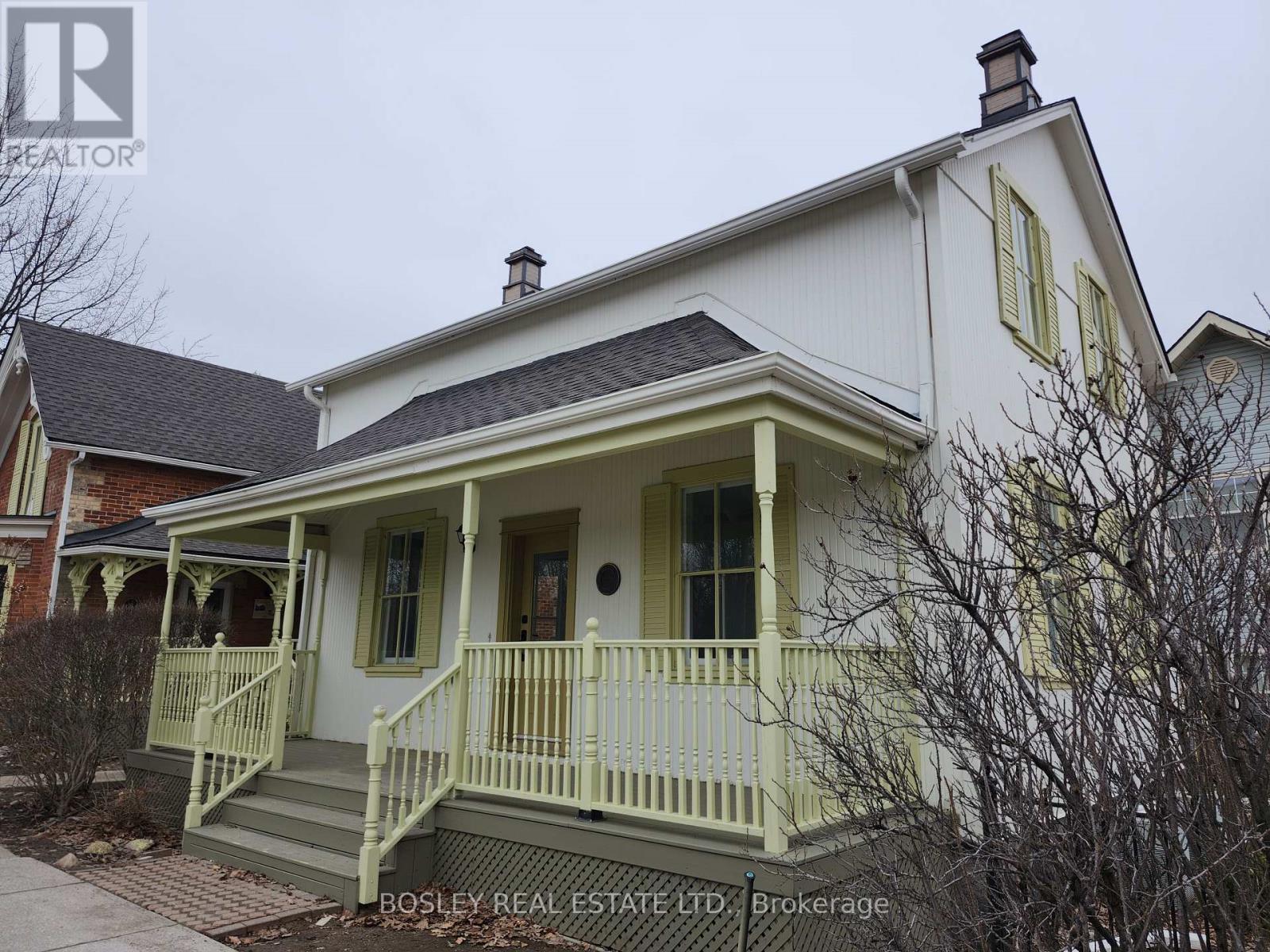 A white house with a green front porch.