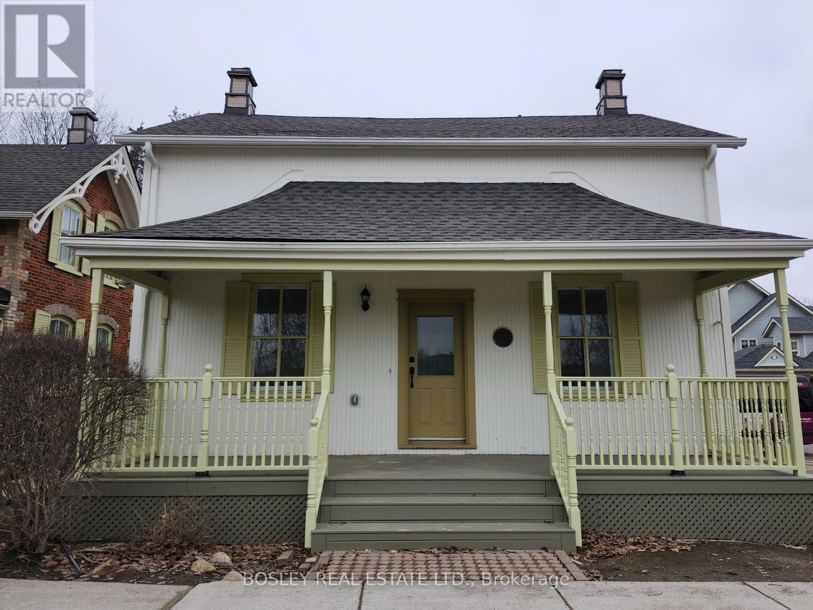 A white house with a green front porch.