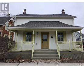 A white house with a green front porch.