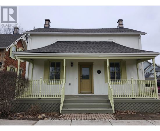 A white house with a green front porch.
