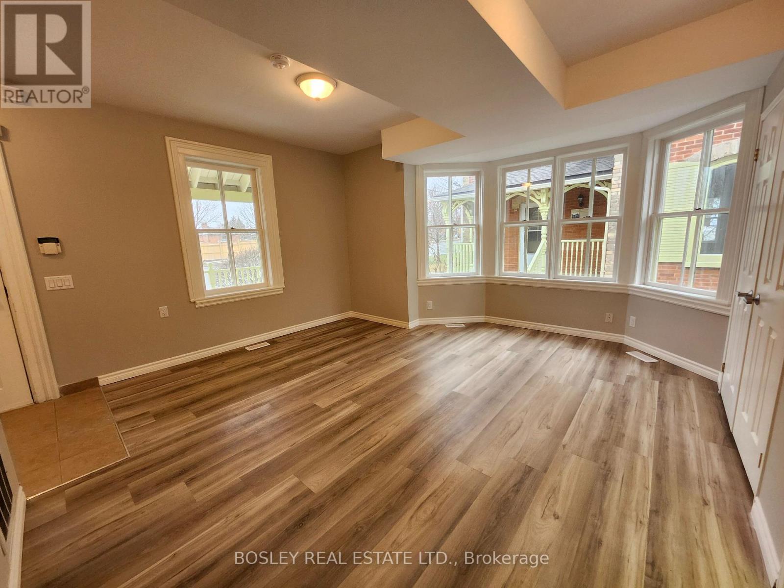 A room with wooden flooring and a large window.