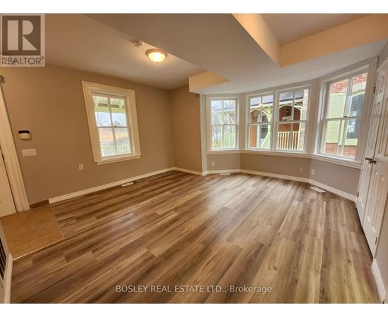 A room with wooden flooring and a large window.