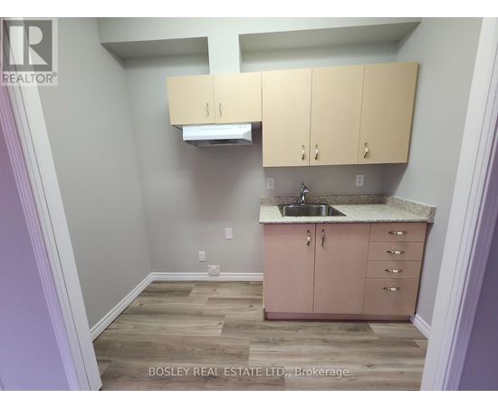 A kitchen area with wooden floors and a sink.